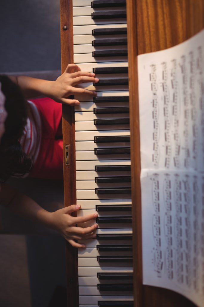 Alumna practicando durante una clase de piano con partituras